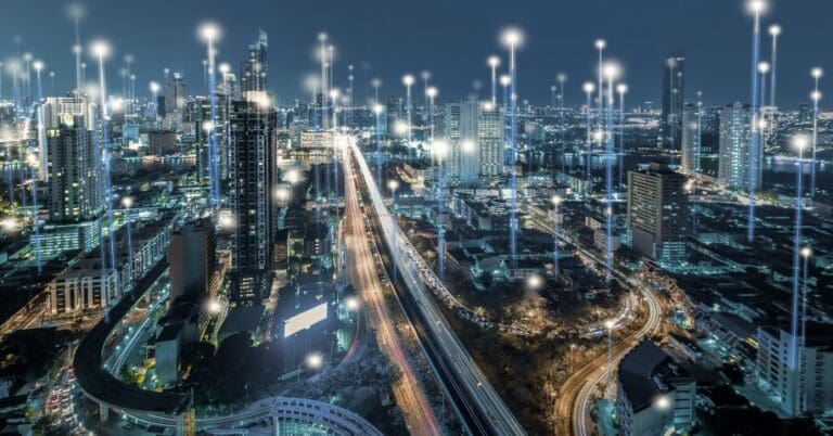 A city scape at night with points of vertical light beams scattered throughout it.