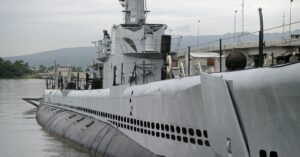 A gray submarine on the surface of the water.