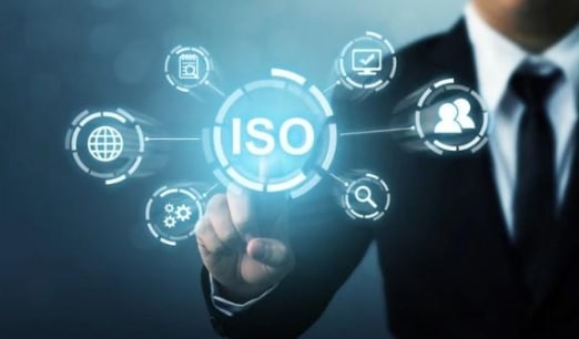 A person in a suit touching a screen with glowing icons that says ISO