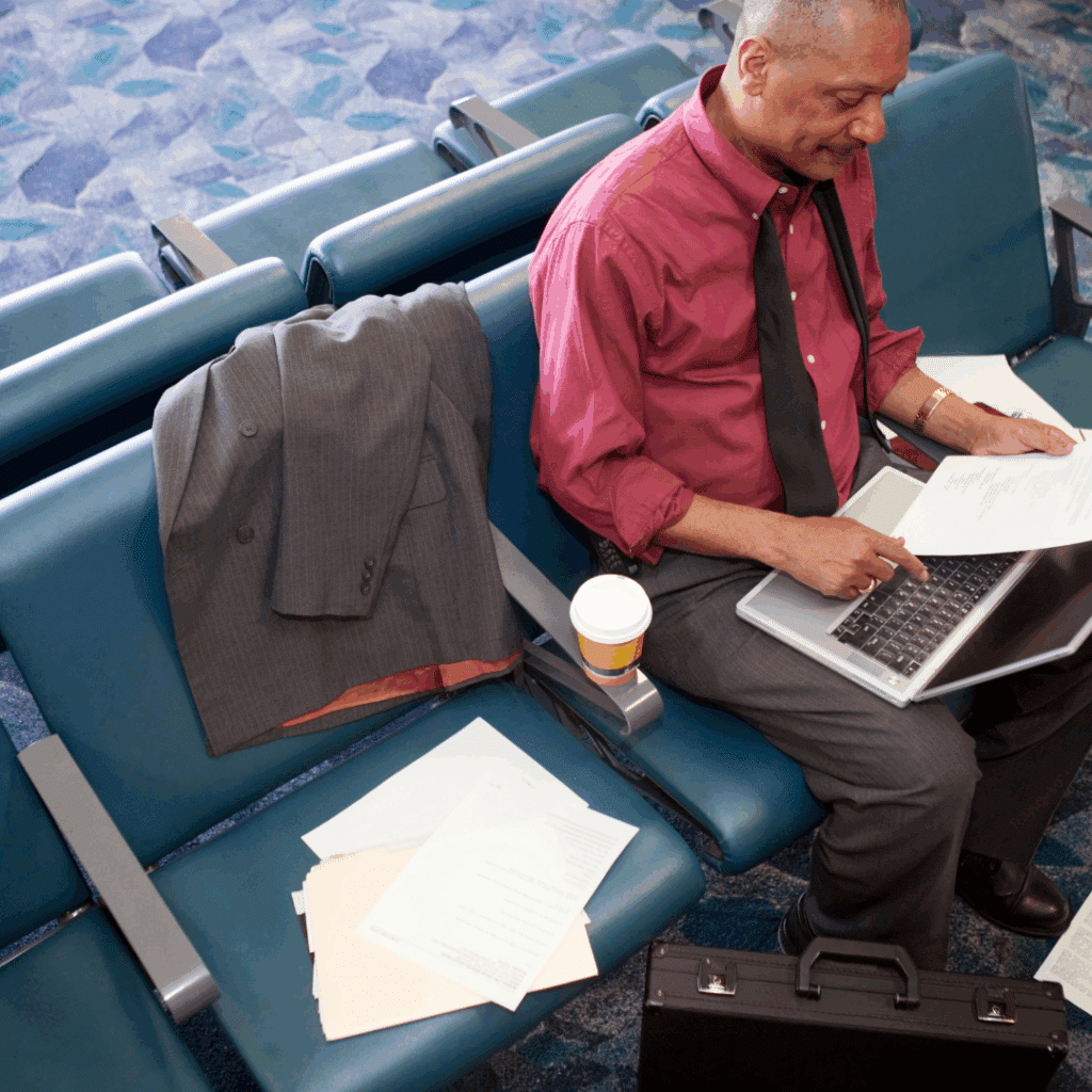 Man working in airport on laptop